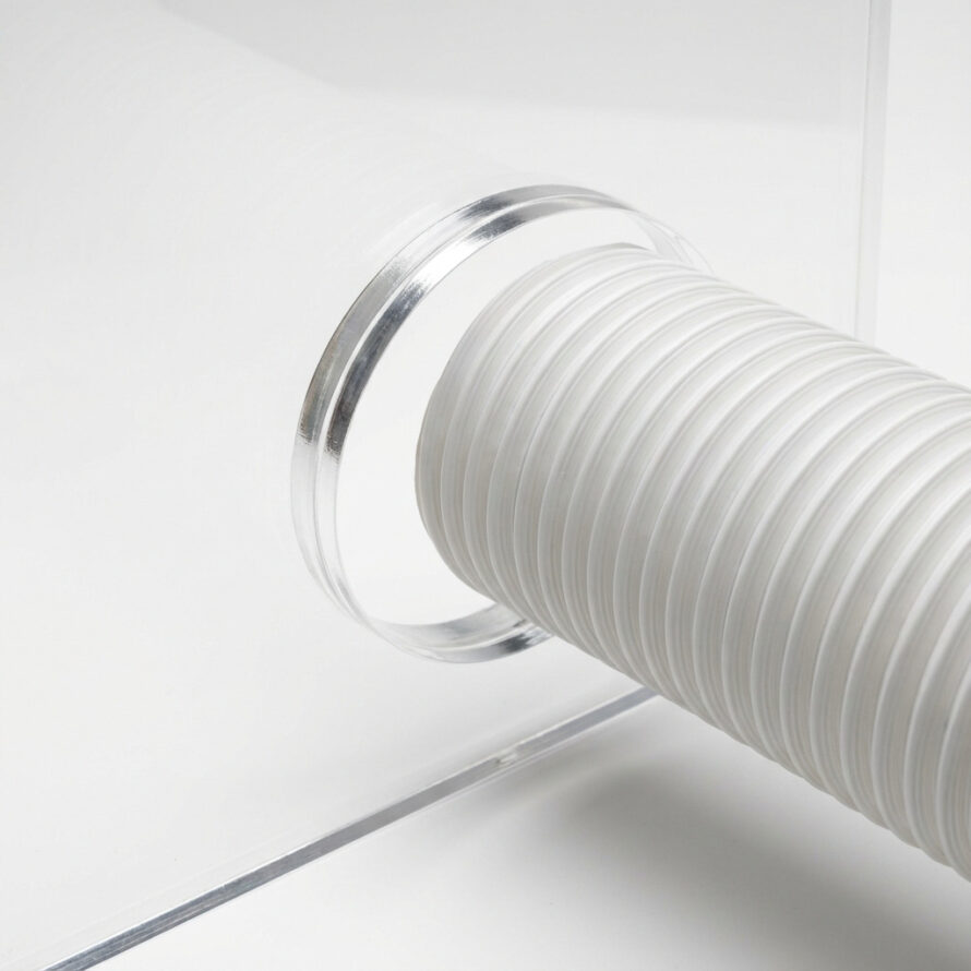 Close-up van plexiglas raamafdichting met CNC-gefreesd rond gat voor airco-afvoerslang.