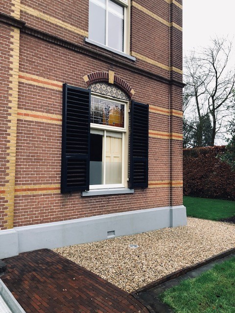 Raam met mat plexiglas in bakstenen gevel van een Nederlandse woning